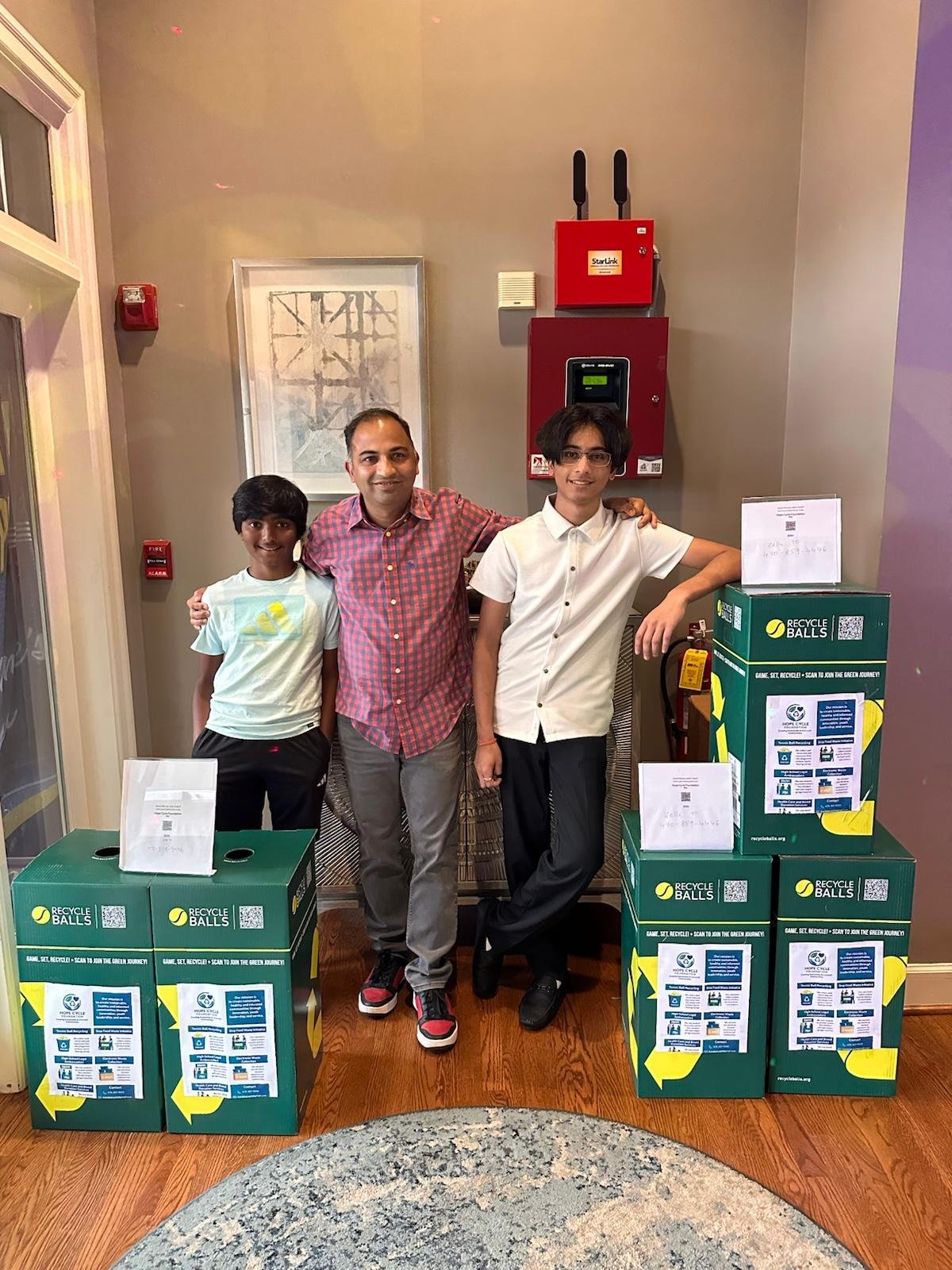 Team with mentor alongside recycling boxes